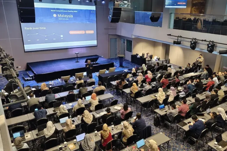 Speaker Mohamed Harun bin Haji Abdul Jabbar addressing an audience at Puncak Ai Training event in a hall